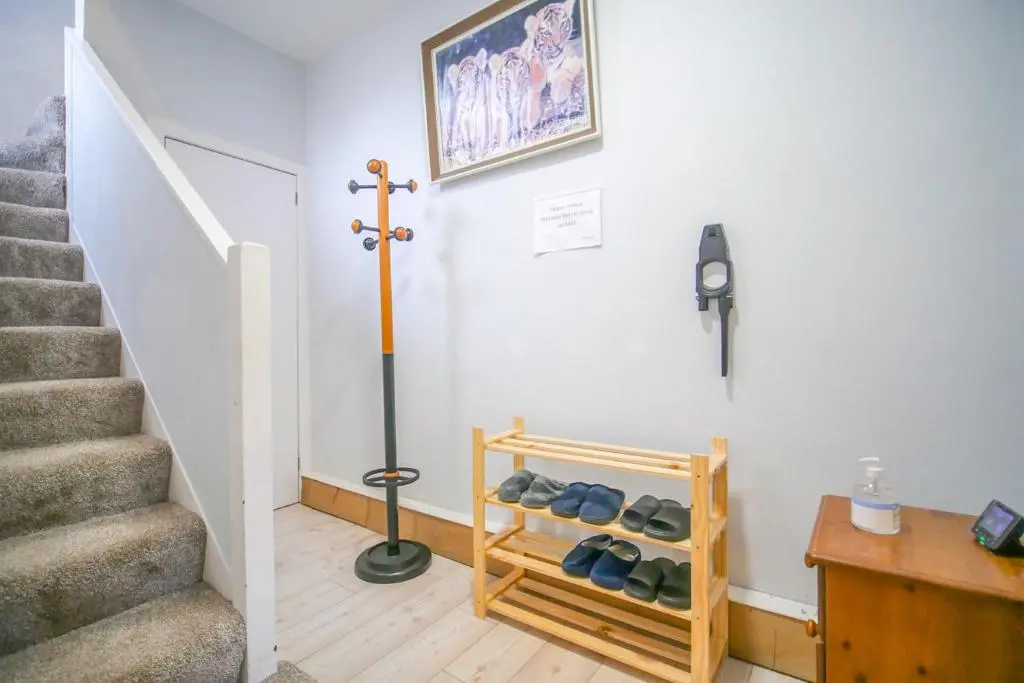a hallway with a staircase with a rack of shoes at Telford St 4 Bedroom House Inverness in Inverness