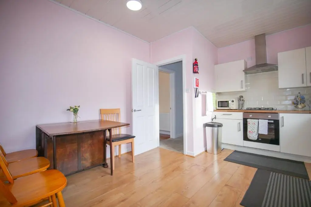 a kitchen with a table and a dining room at Telford St 4 Bedroom House Inverness in Inverness