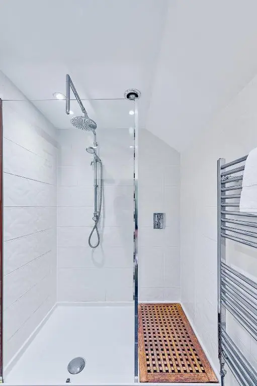 a bathroom with a shower with a glass door at Kinkell House Rooms in Cononbridge