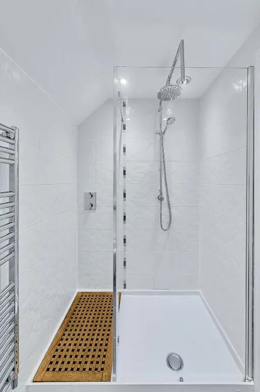 a white bathroom with a shower with a glass door at Kinkell House Rooms in Cononbridge