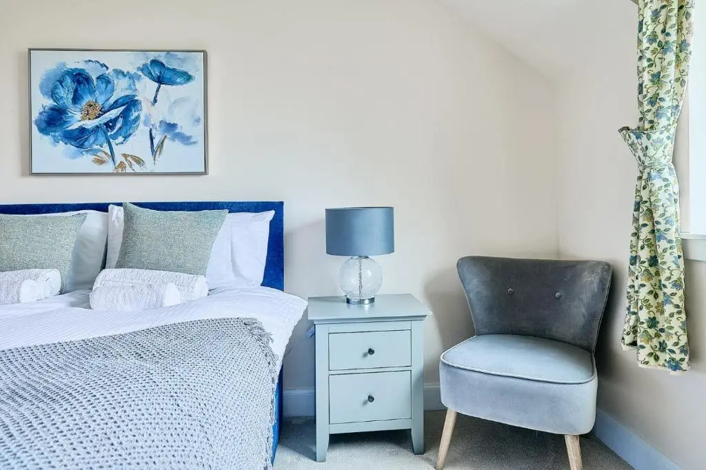 a bedroom with a bed and a chair at Kinkell House Rooms in Cononbridge