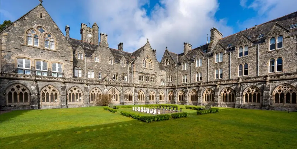 a large building with a grass yard in front of it at Abbey Church Upper North Aisle Luxury Self Catering 2 bedroom Apartments in Fort Augustus