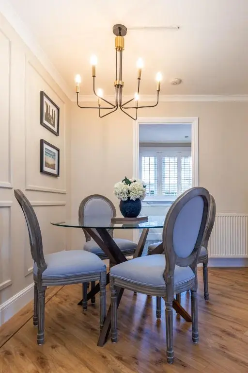 a dining room with a table with chairs and a chandelier at Apartment 91 in Inverness