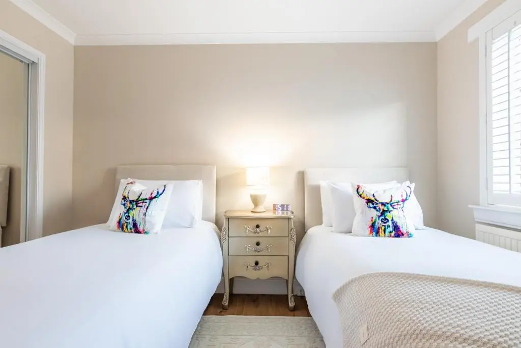 two twin beds in a bedroom with a night stand at Apartment 91 in Inverness