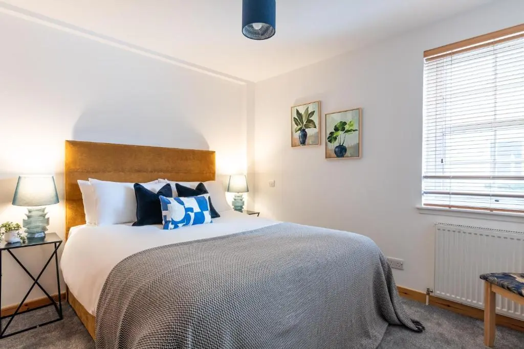 a bedroom with a large bed with blue pillows at Ness Station in Inverness