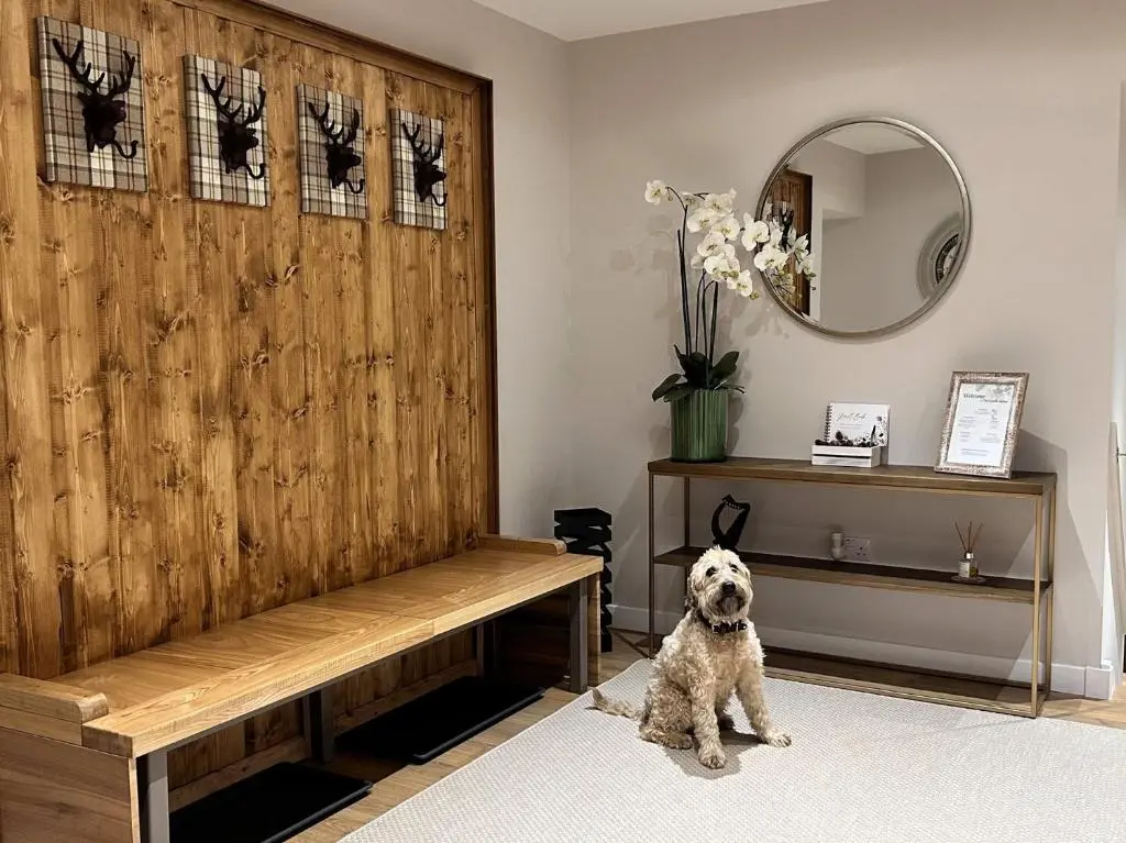 a dog sitting in front of a wooden wall at 4 Bed in Dyce 93914 in Dyce