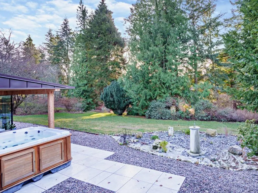 a backyard with a hot tub and a garden at 4 Bed in Dyce 93914 in Dyce