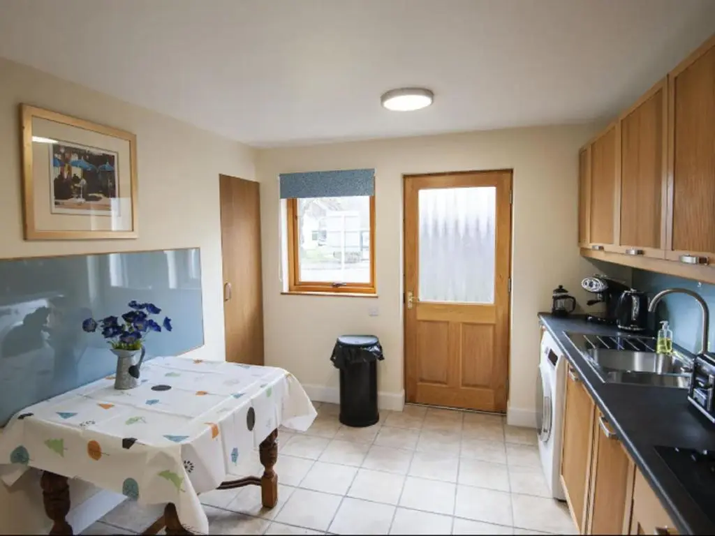 a kitchen with a table with a vase of flowers on it at Holiday Home Oakdale House by Interhome in Drumnadrochit
