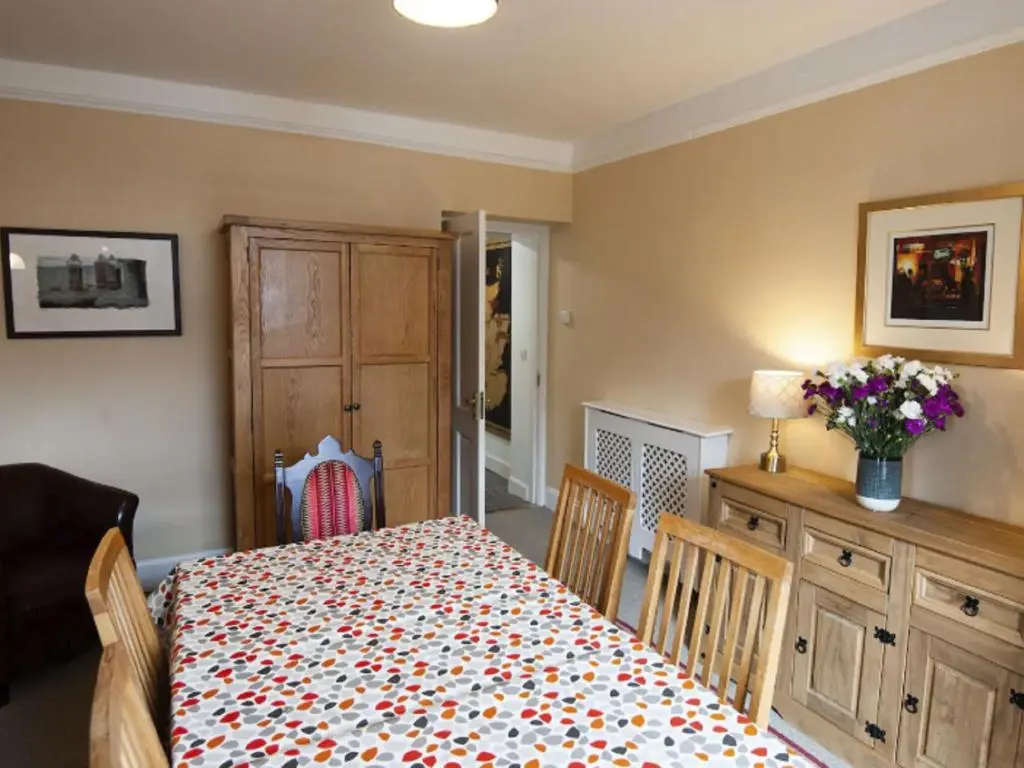 a bedroom with a bed and a table with chairs at Holiday Home Oakdale House by Interhome in Drumnadrochit