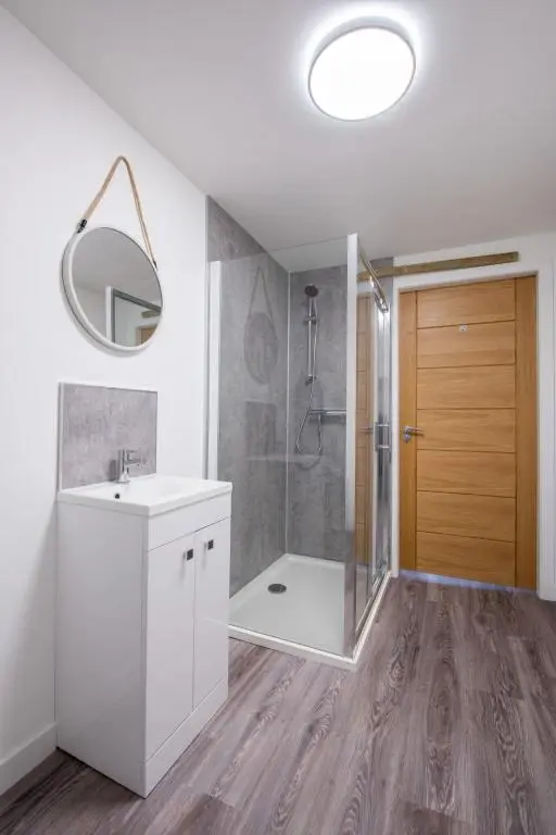 a bathroom with a shower and a sink and a mirror at Apartment Harbour Nights Deluxe 7C by Interhome in Lossiemouth