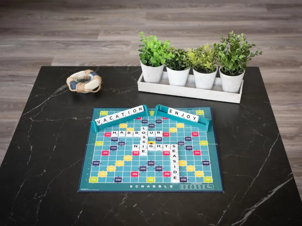 a monopoly game on a table with potted plants at Apartment Harbour Nights Deluxe Number 12 by Interhome in Lossiemouth