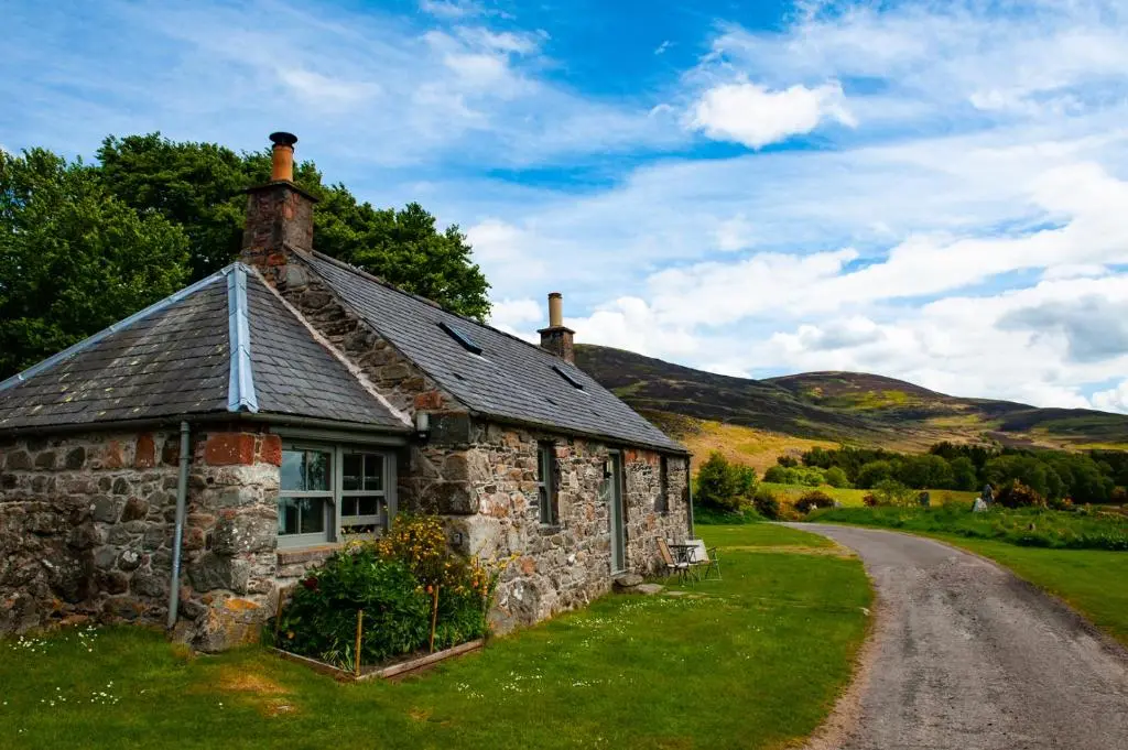 an old stone house on the side of a road at Colmeallie Bothy - Seasgair Lodges in Brechin