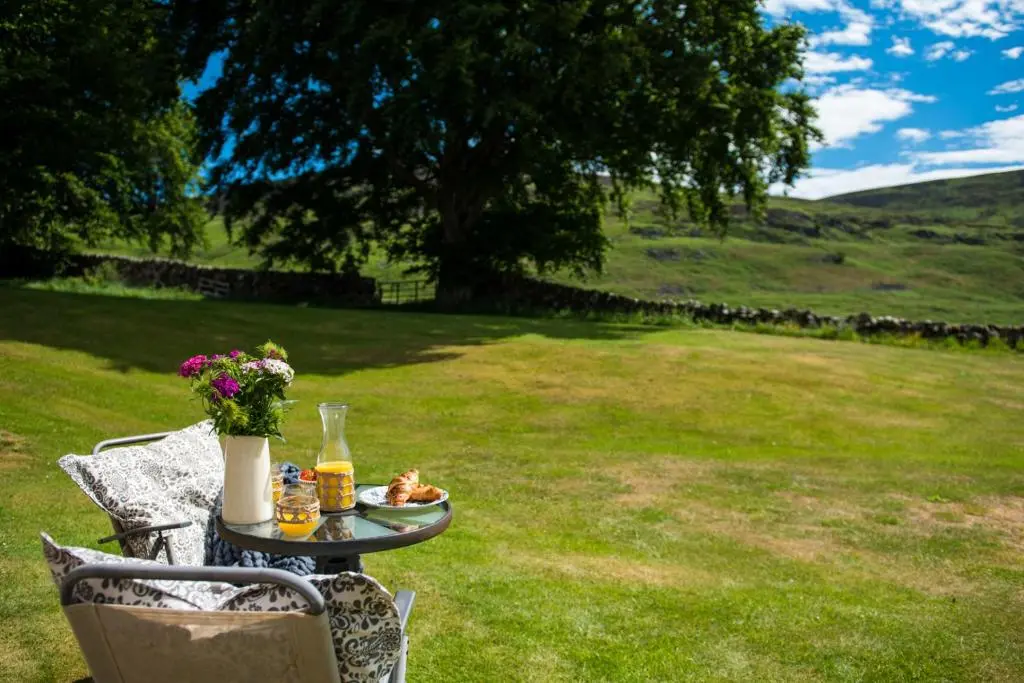 a table with a plate of food on a lawn at Colmeallie Bothy - Seasgair Lodges in Brechin