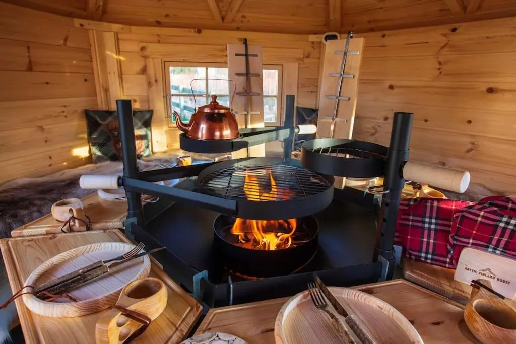 a room with a fireplace in a log cabin at Cosy Shepherds Hut with hot tub in the Scottish Highlands in Stittenham