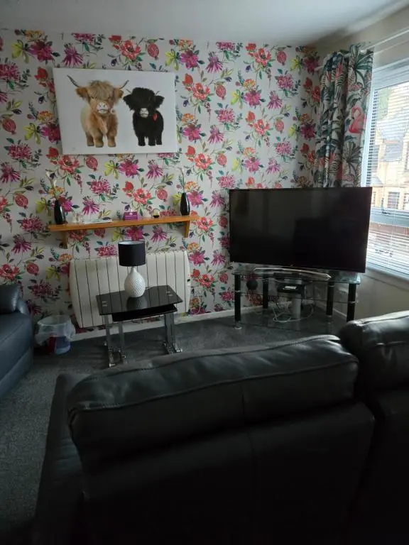a living room with a flat screen tv and a couch at No 70G in Inverness