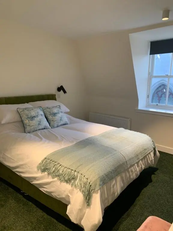 a bedroom with a large bed with a window at STAG & THISTLE HOTEL AND RESTAURANT in Fraserburgh