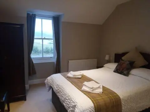a bedroom with a bed with two towels on it at Glenisla Hotel in Blairgowrie