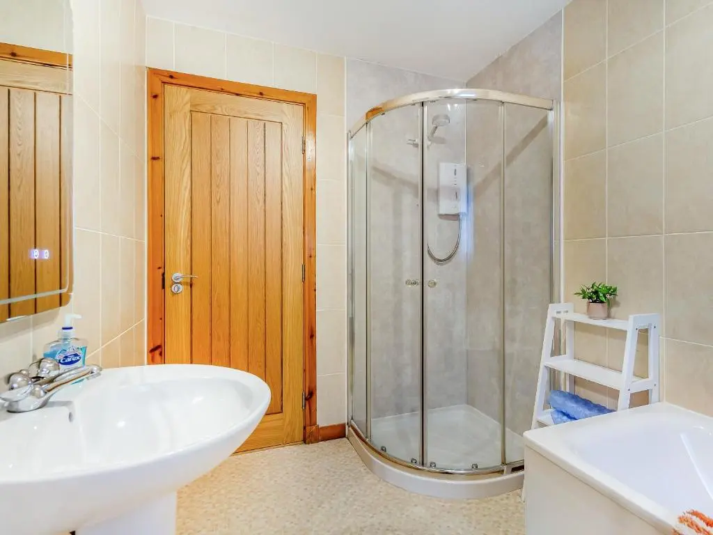 a bathroom with a shower and a sink and a toilet at Balnagowan Mill in Nethy Bridge