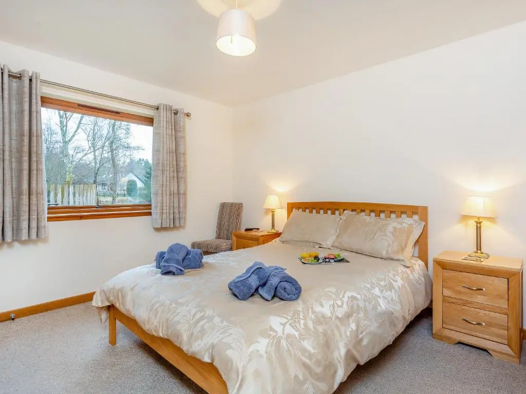 a bedroom with a bed with blue towels on it at Balnagowan Mill in Nethy Bridge