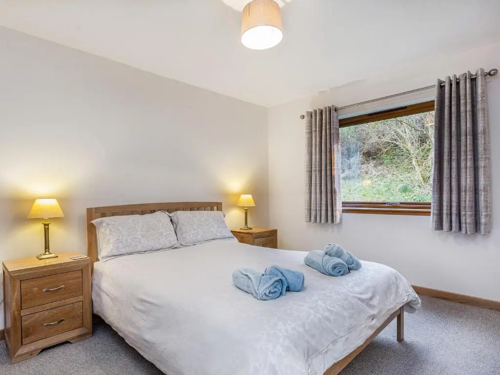 a bedroom with a bed with two towels on it at Balnagowan Mill in Nethy Bridge
