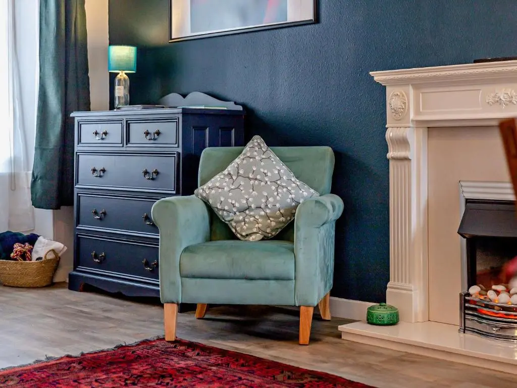 a green chair with a pillow in a living room at 1 Bed in Cullen 94536 in Cullen