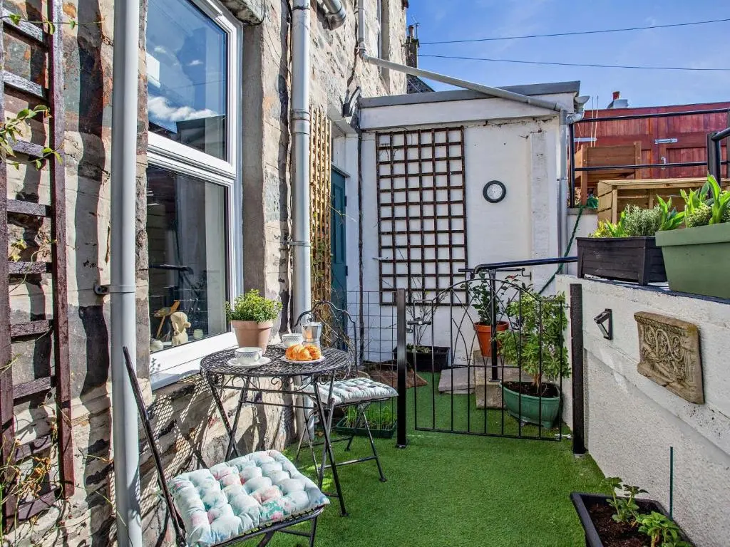 a small courtyard with a table and chairs on a balcony at 1 Bed in Cullen 94536 in Cullen