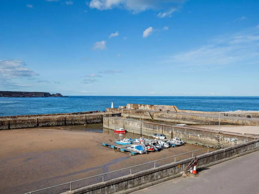 a group of boats parked on the beach near the water at 1 Bed in Cullen 94536 in Cullen