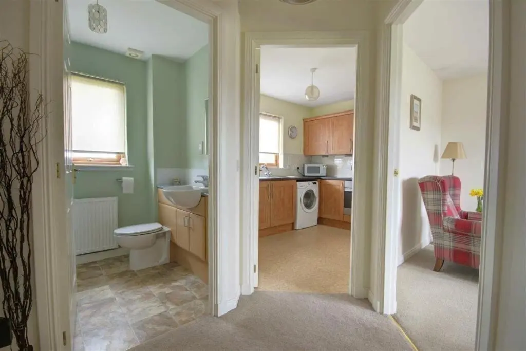 a bathroom with a sink and a toilet in a kitchen at The Old Mill Apartment, on NC500 in Brora