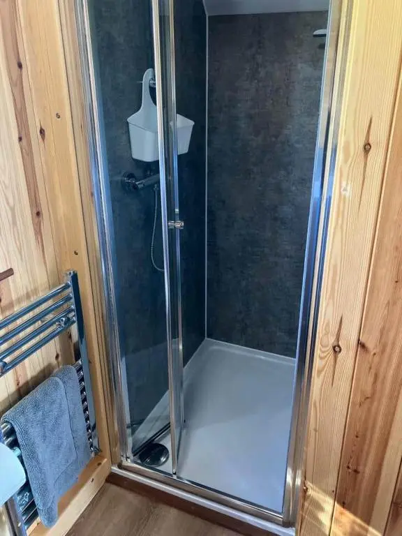 a shower with a glass door in a bathroom at Migdale Pods Luxury Glamping in Bonar Bridge