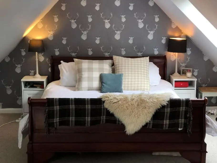 a bedroom with a bed with a blanket and pillows at Spacious Cottage in the Grounds of a Scottish Castle in Insch