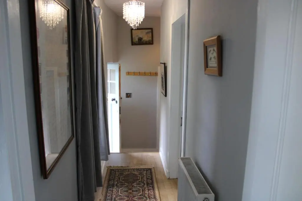 a hallway with a door and a chandelier at Spacious Cottage in the Grounds of a Scottish Castle in Insch