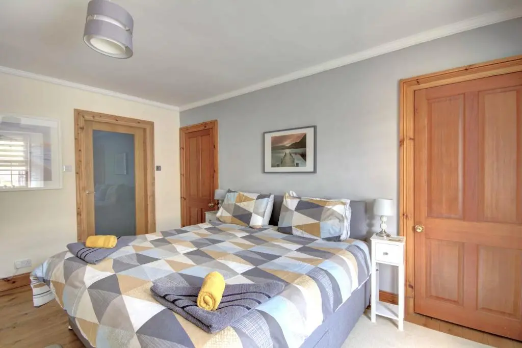 a bedroom with a bed with a checkered blanket at The Apartment at Allt-Sagart in Golspie