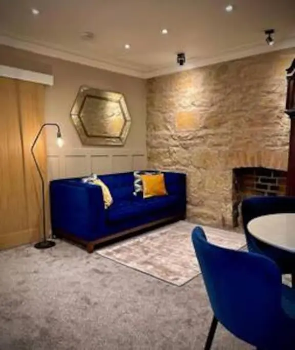 a living room with a blue couch and a fireplace at Treat Yourself To Luxury & Style in Inverness