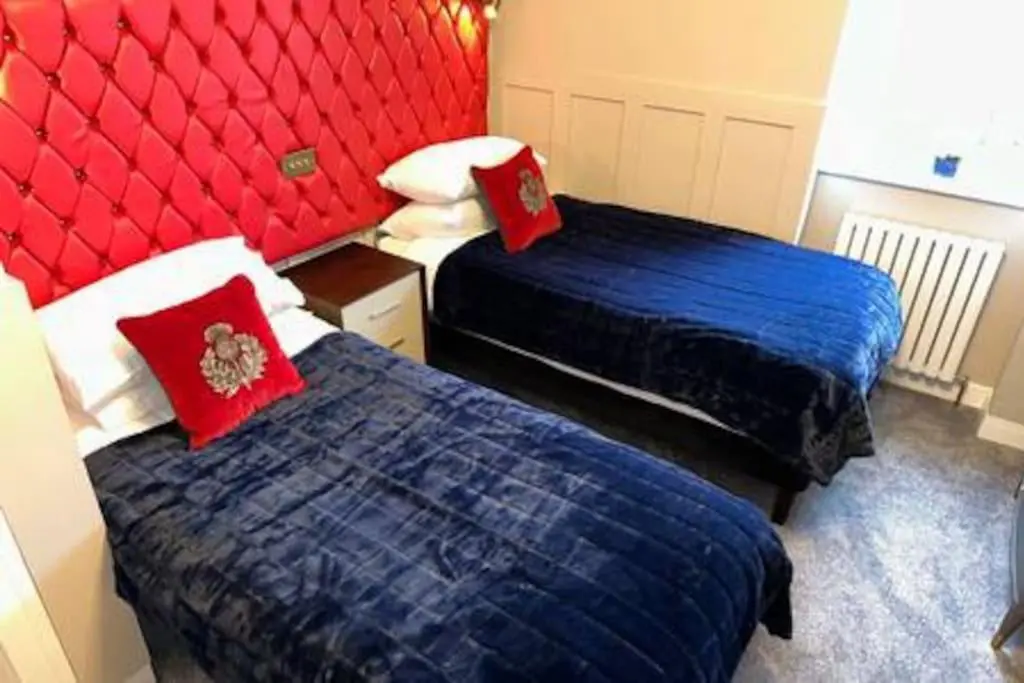 two beds in a room with red and blue at Treat Yourself To Luxury & Style in Inverness