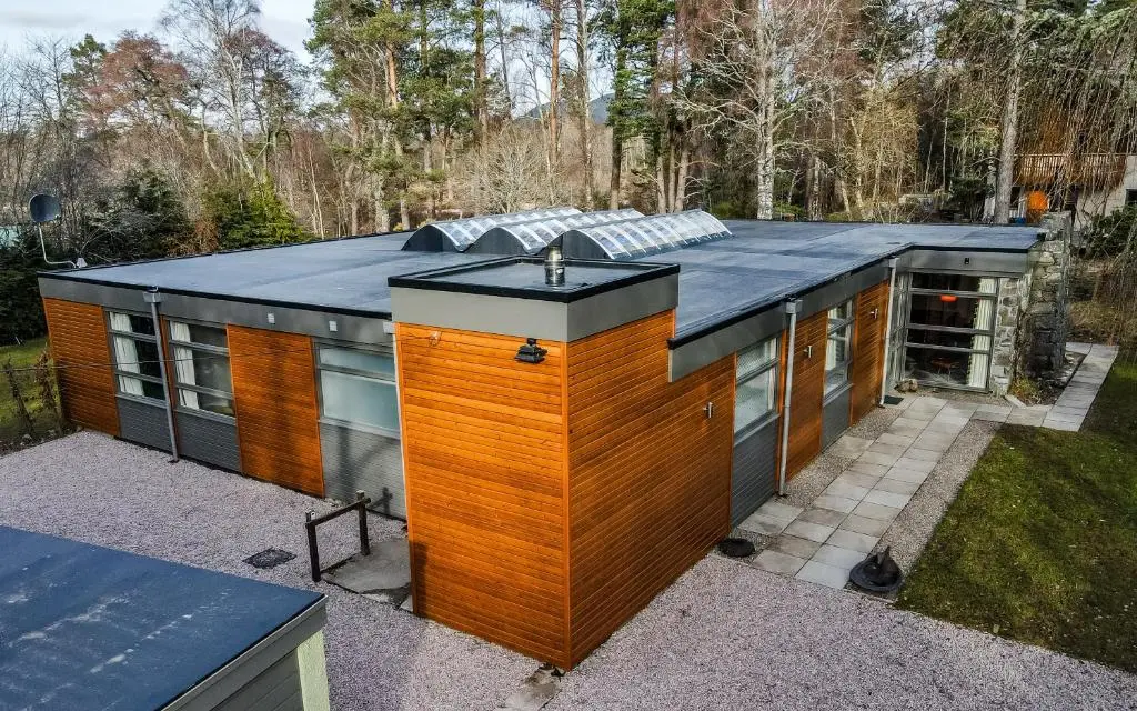a small house with a roof on a yard at Strathy House in Aviemore