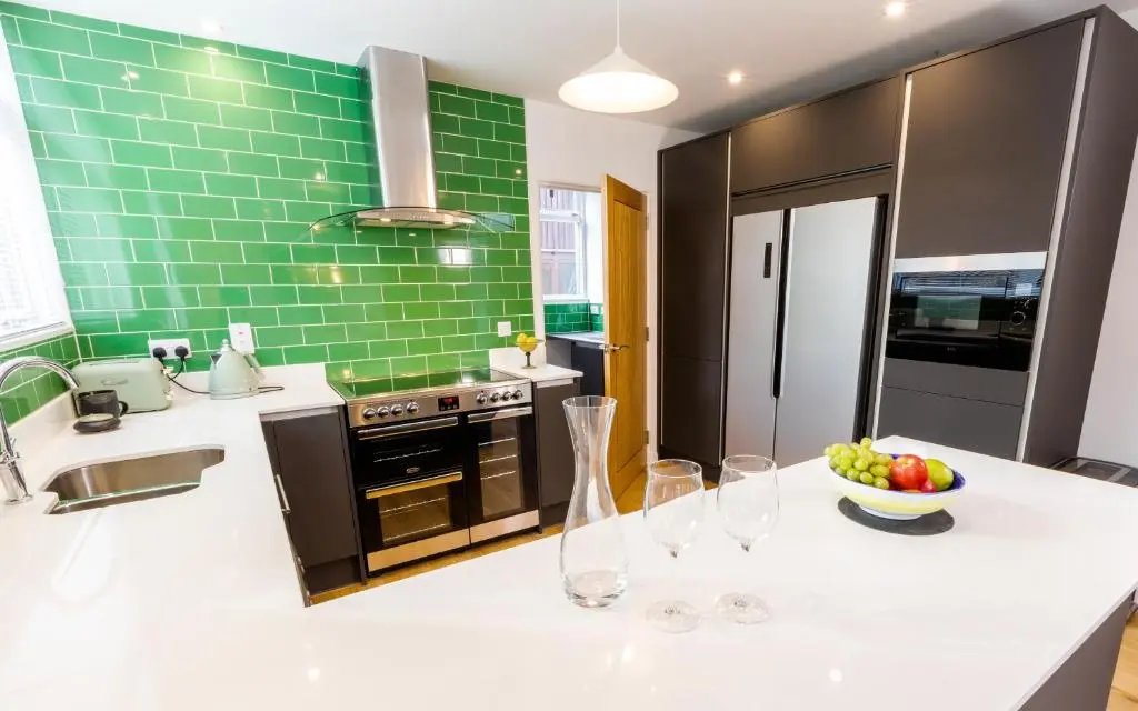 a kitchen with a counter with wine glasses on it at Strathy House in Aviemore