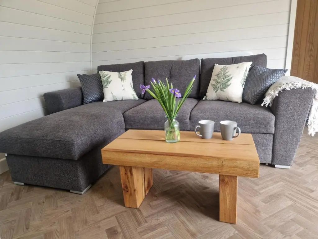 a living room with a couch and a table with flowers at Bromach Lodge in Latheron