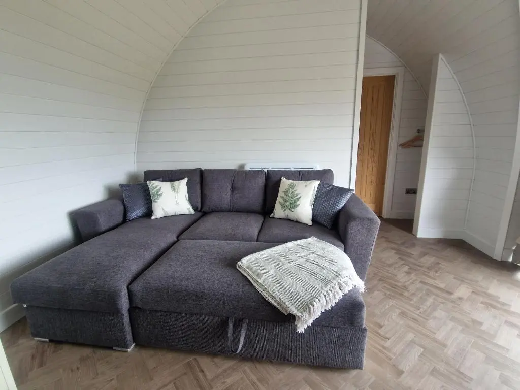 a living room with a couch in a room with an attic at Bromach Lodge in Latheron
