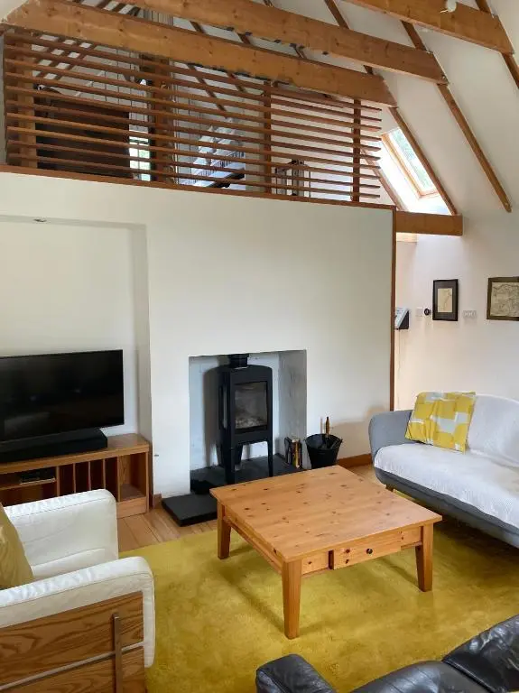 a living room with a table and a fireplace at Stunning Rural Mill House nr beach and harbour in Banff