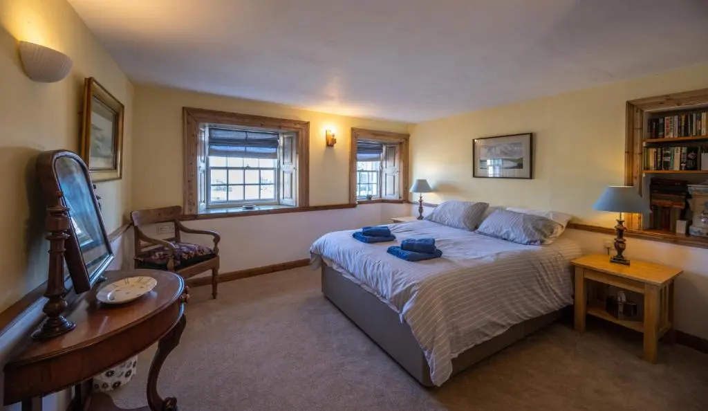 a bedroom with a bed and a table and a chair at 6 Shorehead, Portsoy in Portsoy