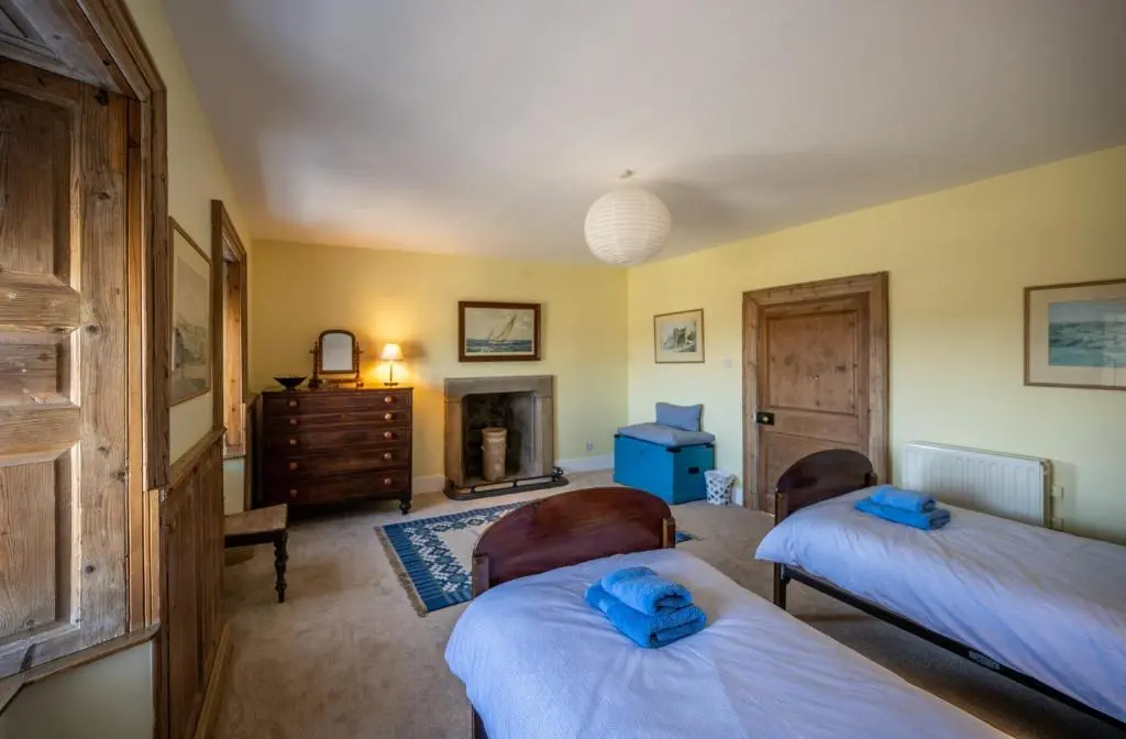a bedroom with two beds and a fireplace at 6 Shorehead, Portsoy in Portsoy