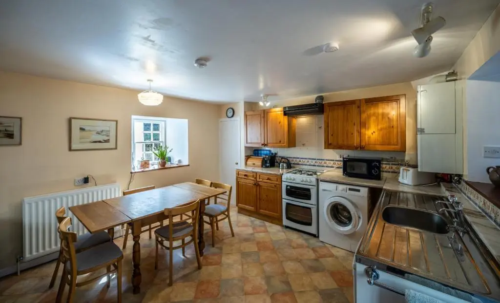 a kitchen with a wooden table and a dining room at 6 Shorehead, Portsoy in Portsoy