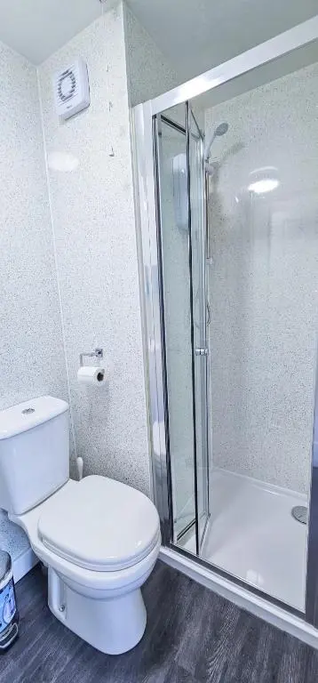 a bathroom with a toilet and a glass shower at Lovat 2 Bedroom Apartment - Inverness in Inverness