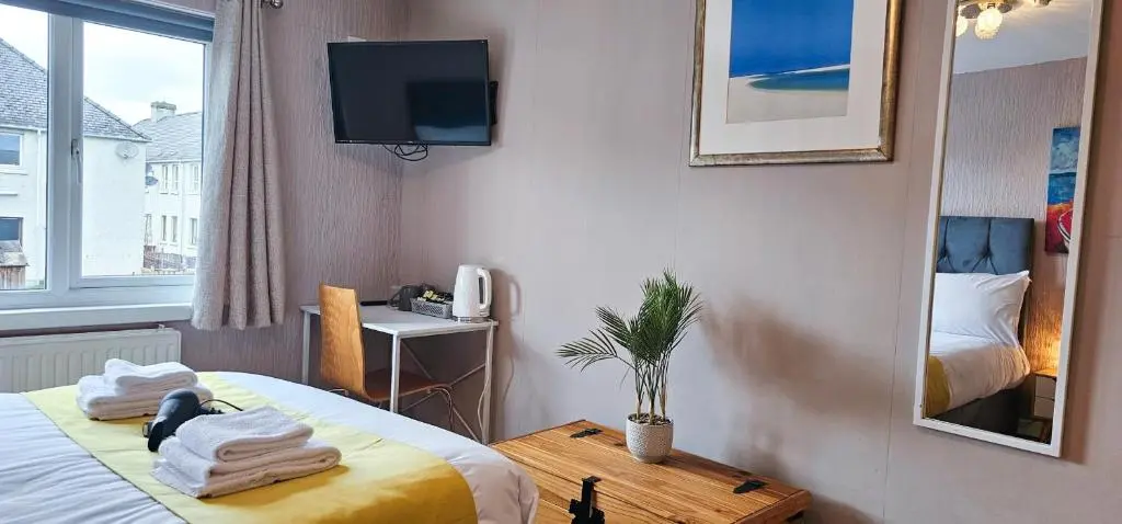 a hotel room with a bed and a television at Lovat 2 Bedroom Apartment - Inverness in Inverness