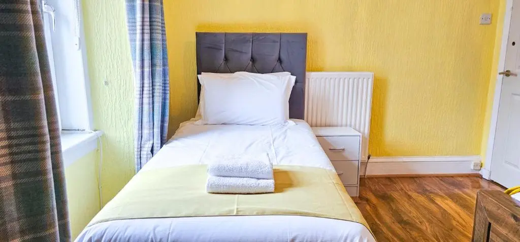 a small bedroom with a bed with a headboard at Fraser 2 Bedroom Apartment - Inverness in Inverness