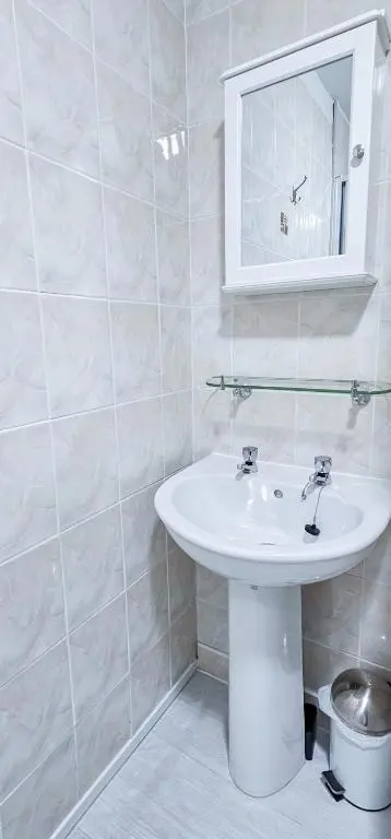 a white bathroom with a sink and a mirror at Fraser 2 Bedroom Apartment - Inverness in Inverness