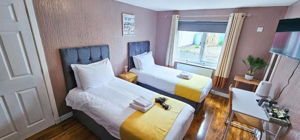 a hotel room with two beds and a window at mySTAYINN Inverness Guest House - Rooms in Inverness