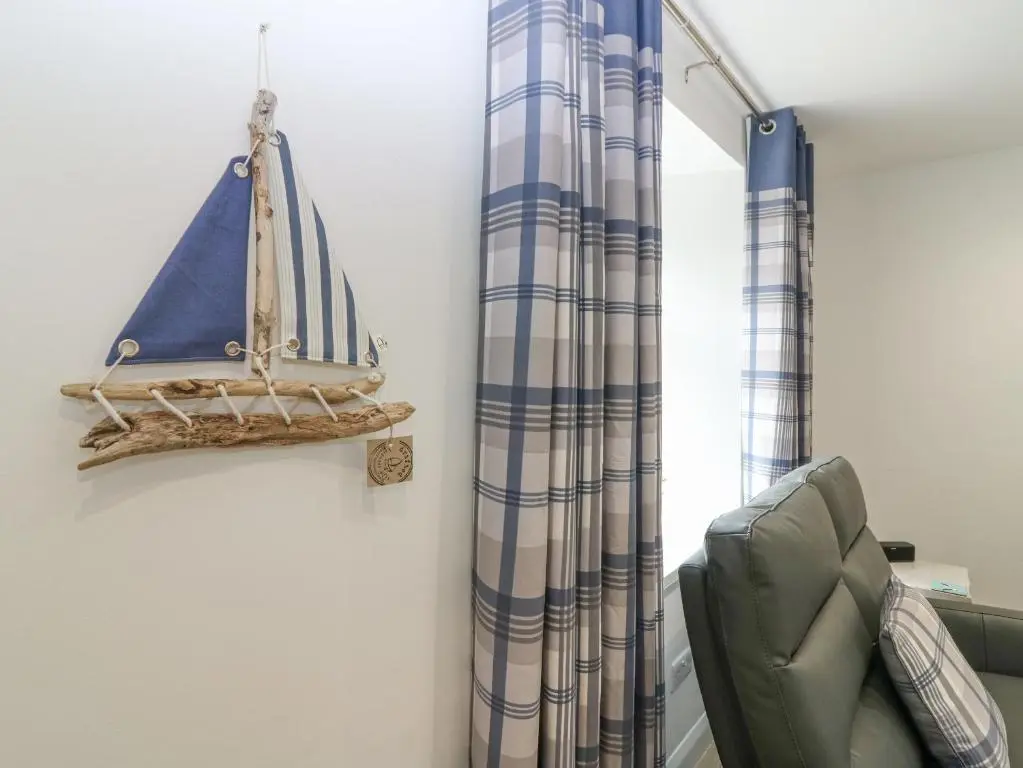 a room with a curtain and a sailboat on the wall at 2 College Bounds in Fraserburgh