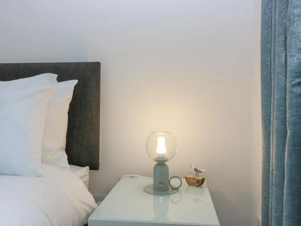 a lamp on a table next to a bed at 2 College Bounds in Fraserburgh