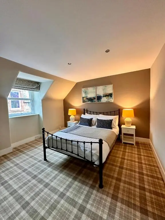 a bedroom with a bed and two lamps in it at Warm and Cosy City Centre House in Inverness